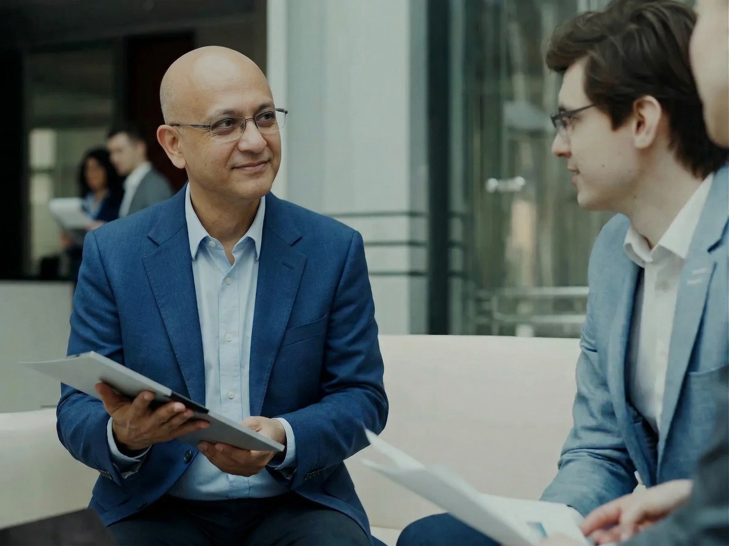 Consultant discussing strategy with two business clients in a modern office